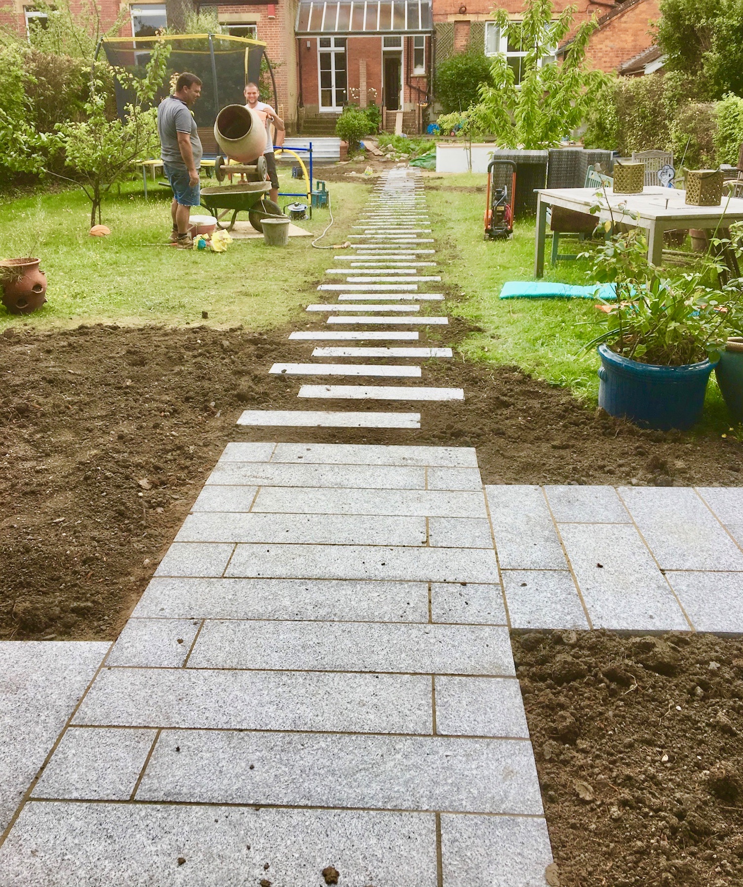A granite stepping-stone path being laid through a lawn