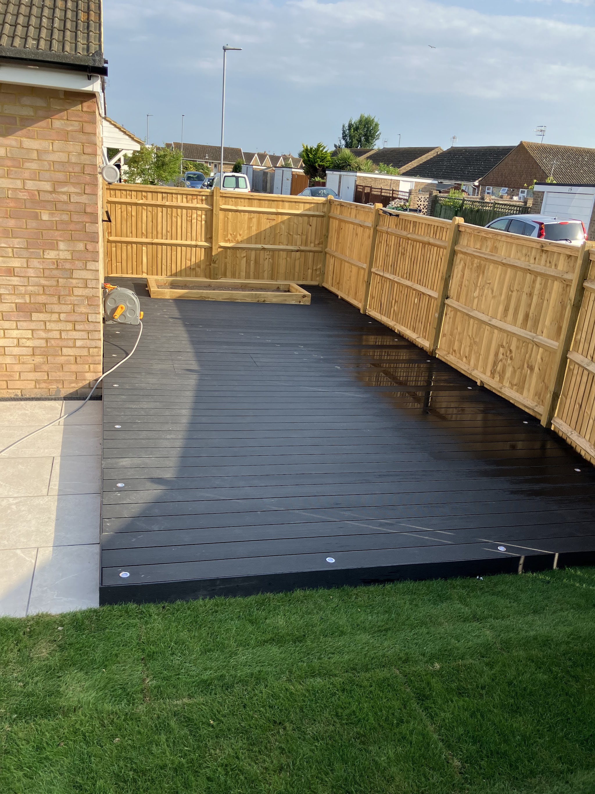 Composite decking with new fencing and a lawn, photographed by a client