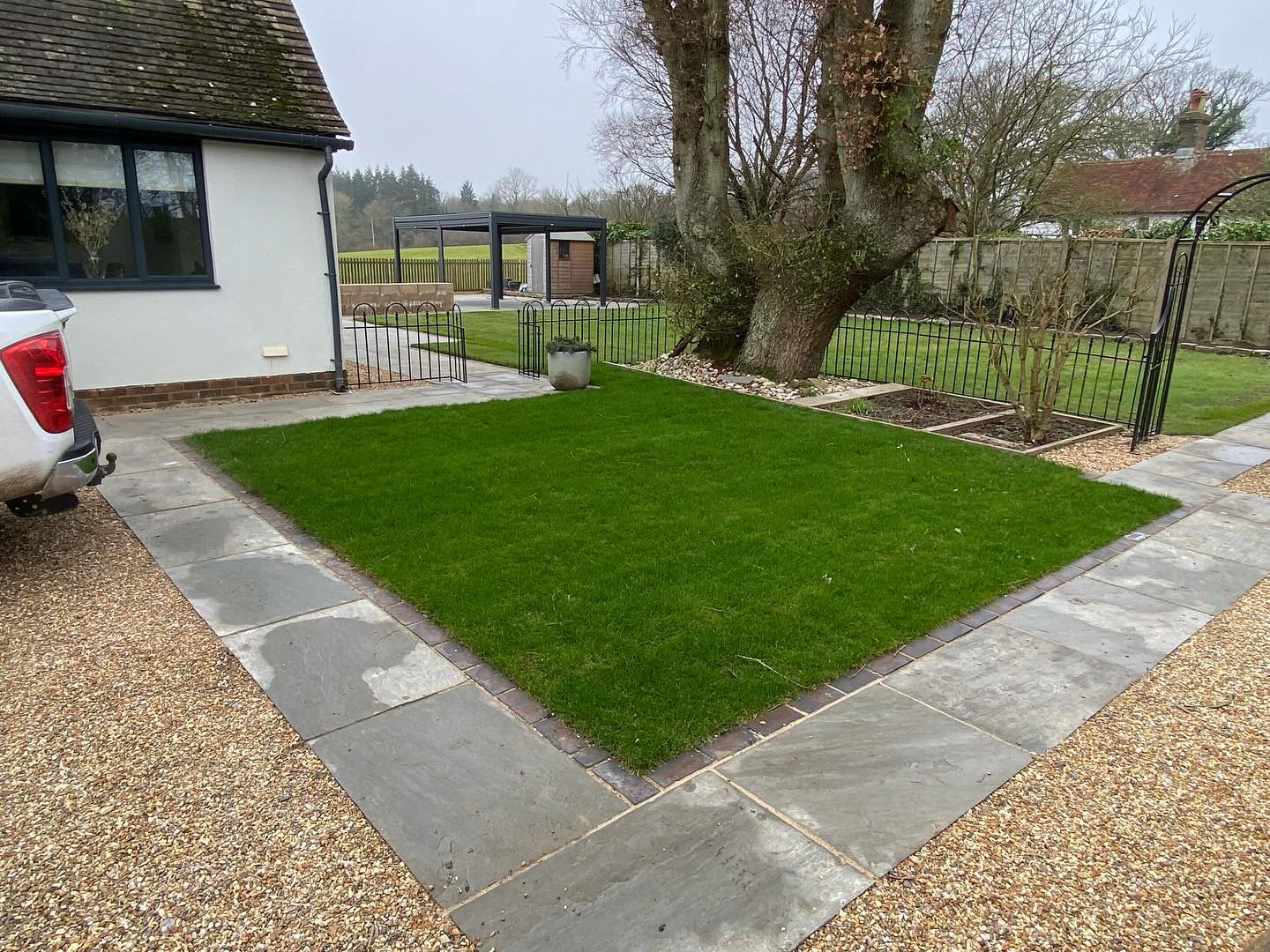 A neat new lawn edged with grey slabs and gravel